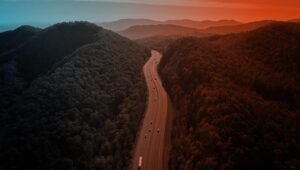 a duotone filtered image of cars driving through mountains